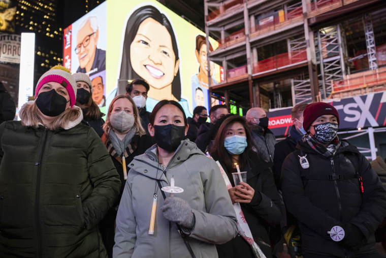 People hold candles during a vigil in honor of Michelle Alyssa Go, a victim of a subway attack, Jan. 18, 2022, in New York's Times Square.