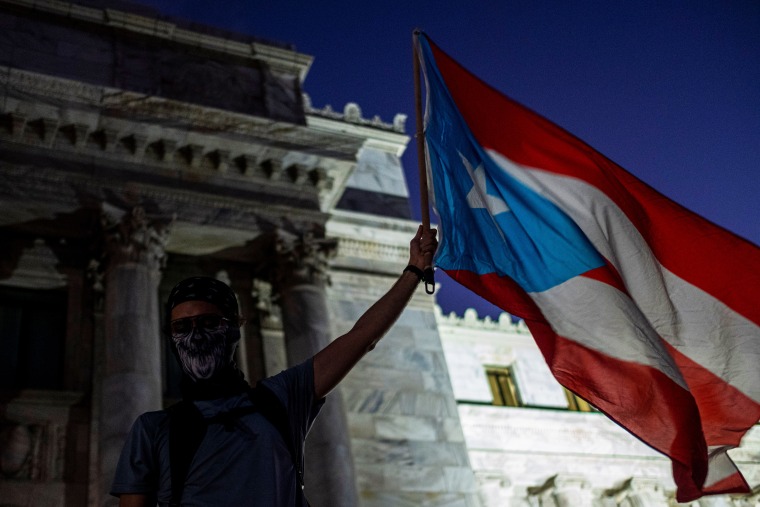 A demonstrator waves a flag in front of Puerto Rico's Capitol during a protest against Puerto Rico Governor Wanda Vazquez and the government in San Juan on Jan. 20, 2020.