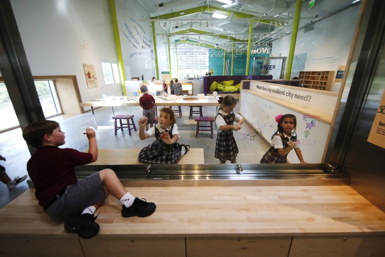 School children draw on a glass panel during a preview of the Louisiana Children's Museum in New Orleans on Aug. 27, 2019.