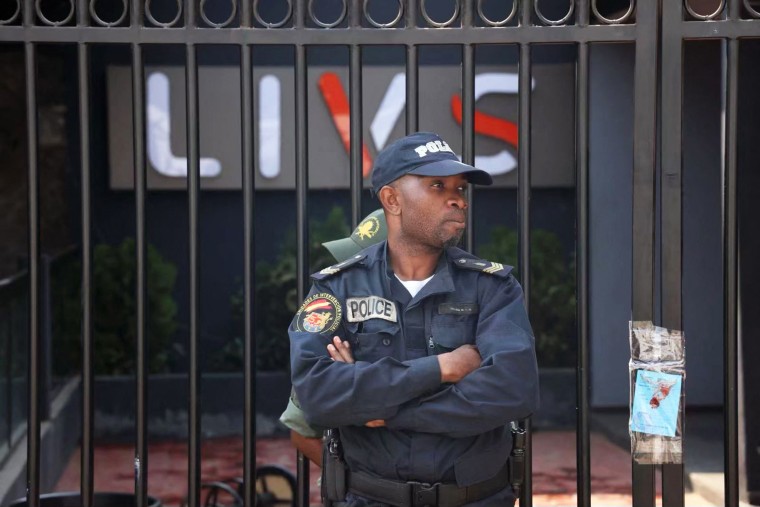 A policeman stands guard at the entrance of the Livs nightclub where a deadly fire occurred in the Bastos district of Yaounde, Cameroon, on Jan. 23, 2022.