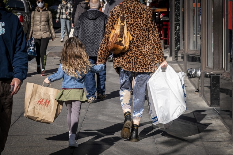 Pedestrians carry shopping bags on Powell Street in San Francisco on Dec. 30, 2021.