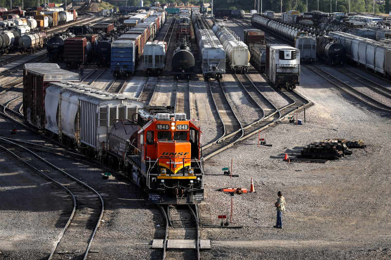 A BNSF rail terminal worker monitors the departure of a freight train, on June 15, 2021, in Galesburg, Ill.