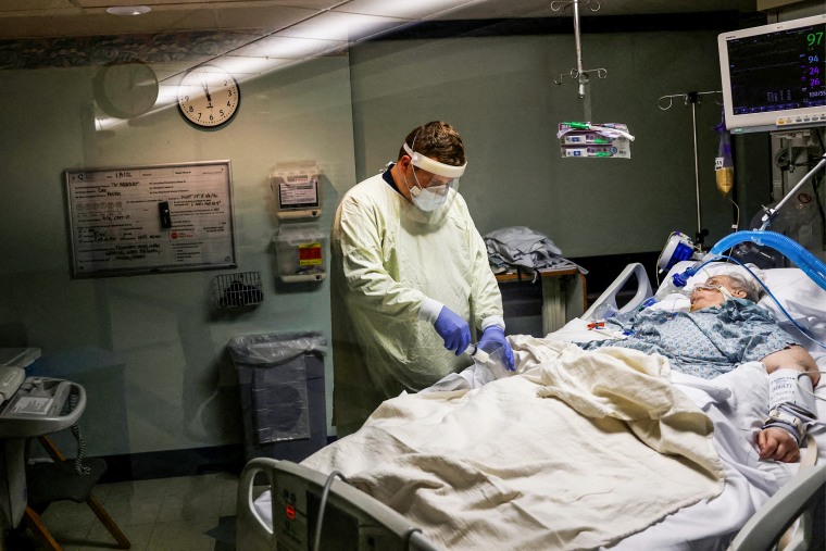 Medical staff treat a Covid-19 patient in their isolation room on the Intensive Care Unit at Western Reserve Hospital in Cuyahoga Falls, Ohio, on Jan. 5, 2022.