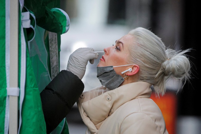 Image: A woman takes a Covid-19 test at a pop-up testing site in New York City on Jan. 12, 2022.