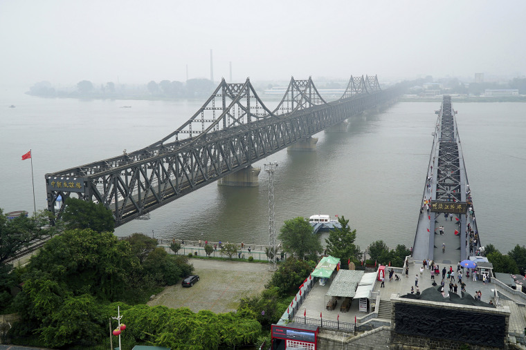 Visitors walk across the Yalu River Broken Bridge, right, next to the Friendship Bridge connecting China and North Korea in September 2017. 