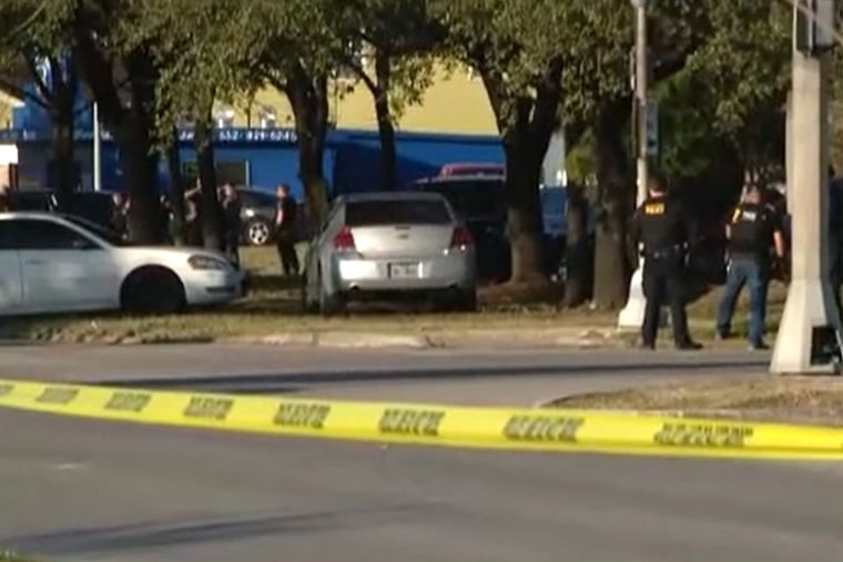 Police investigate the scene of a shooting involving three Houston police officers Thursday.