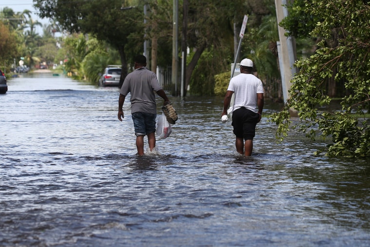 People walk along a flooded street after the passing of Hurricane Irma in North Miami