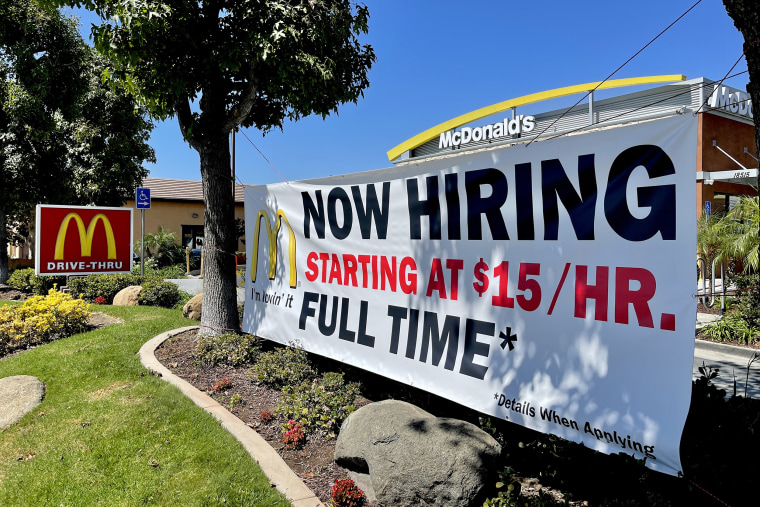 Image: A "Now Hiring" sign at a McDonald's restaurant in Yorba Linda, Calif, offers pay starting at $15 an hour on Sept. 13, 2021.