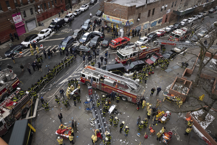 Image: Firefighters work outside an apartment building after a fire in the Bronx, N.Y., on Jan. 9, 2022.