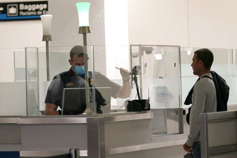 Estados Unidos vuelve a abrir sus fronteras a los refugiados tras la pausa impuesta para gestionar la crisis de los evacuados afganos. En la imagen, un oficial de Aduanas y Protección Fronteriza (CBP, en inglés) revisa la documentación de un viajero en el aeropuerto de Miami en noviembre de 2020.