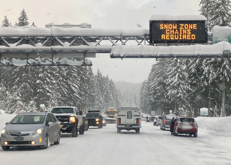 Conductores en Detroit, Oregon, ralentizan el paso ante la poca visibilidad provocada por una fuerte nevada el 26 de diciembre de 2021.