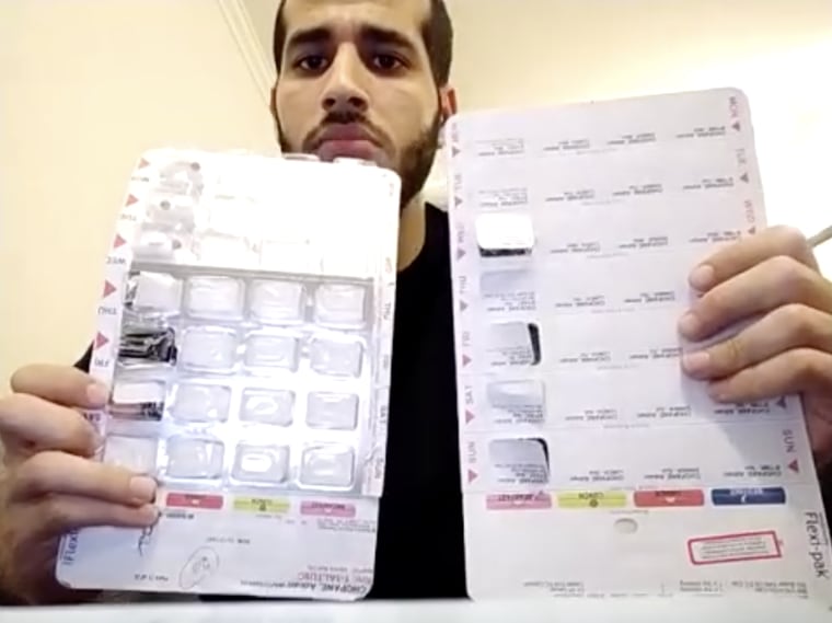 Adnan Choopani holds up medication packs that he said contained antidepressants and sleeping tablets.