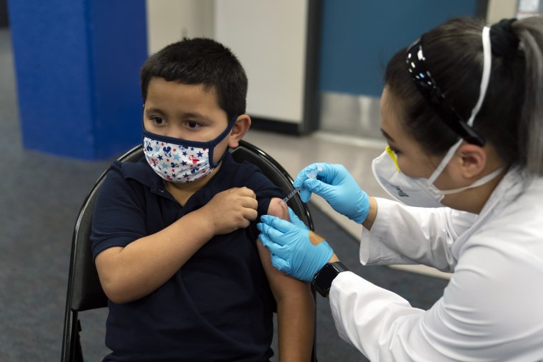 Eric Aviles, de seis años, recibe la vacuna contra el COVID-19 de manos de la farmacéutica Sylvia Uong en una clínica pediátrica en la Escuela Intermedia Willard en Santa Ana, California, el martes 9 de noviembre de 2021.