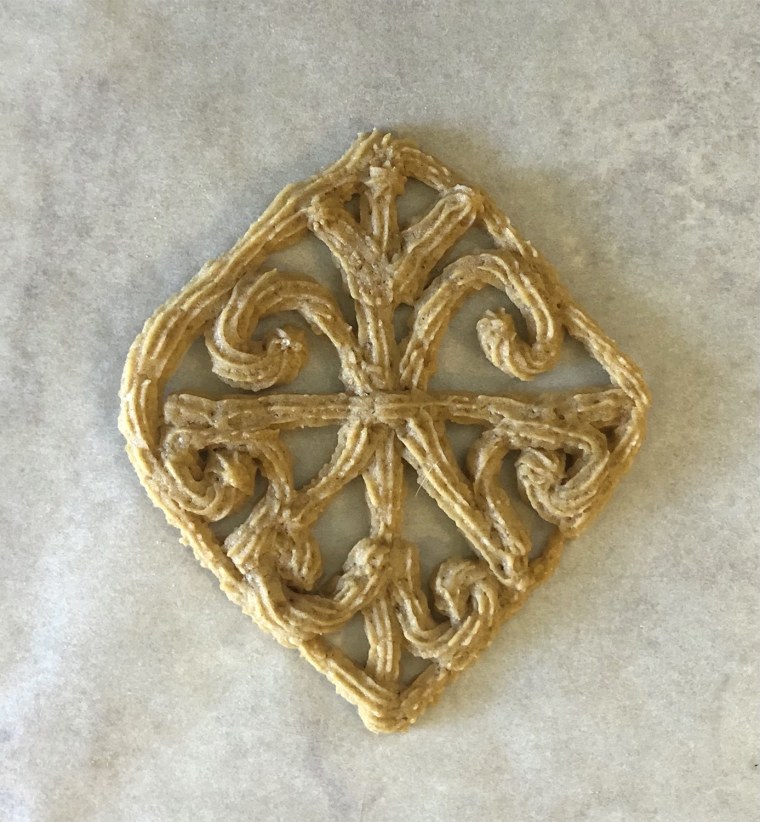 The filigree cookie is a symmetrical design made with soft, piped dough.