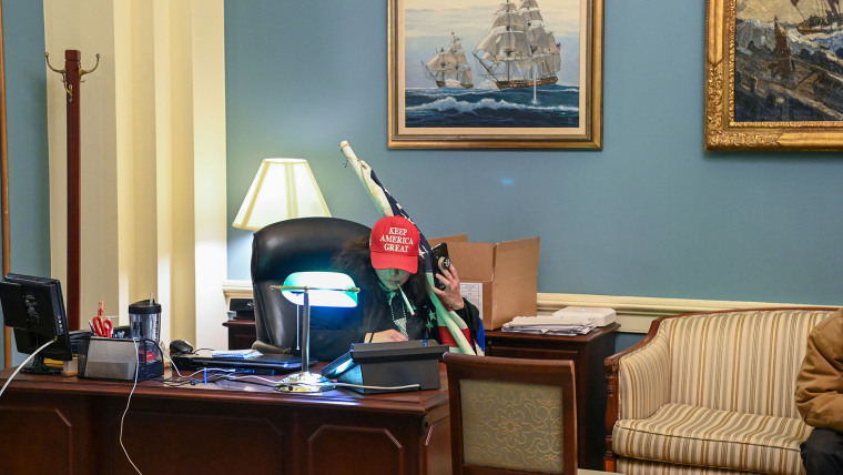 Una simpatizante de Trump se sienta dentro de la oficina de la presidenta de la Cámara de Representantes, Nancy Pelosi, el 6 de enero de 2021.