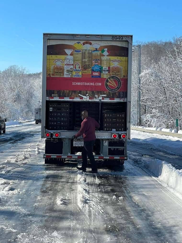 Ron Hill, a truck driver for Schmidt Baking Company, opened up the back of the truck to distribute loaves of bread and rolls to people stranded on icy I-95 in Virginia on Tuesday.