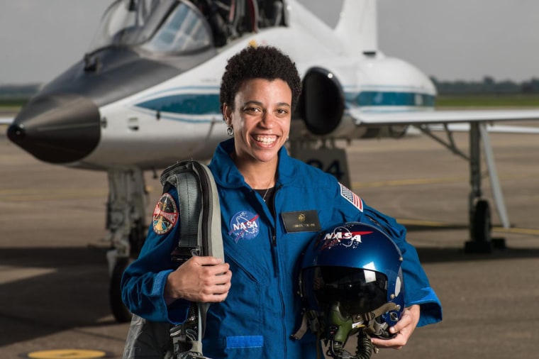 Jessica Watkins, the first Black woman set to be a part of an International Space Station crew, displays Black joy as she poses for a picture in front of a plane.