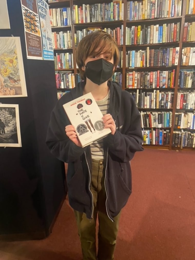 A Banned Book Club student poses with their latest read, "The Hate U Give."