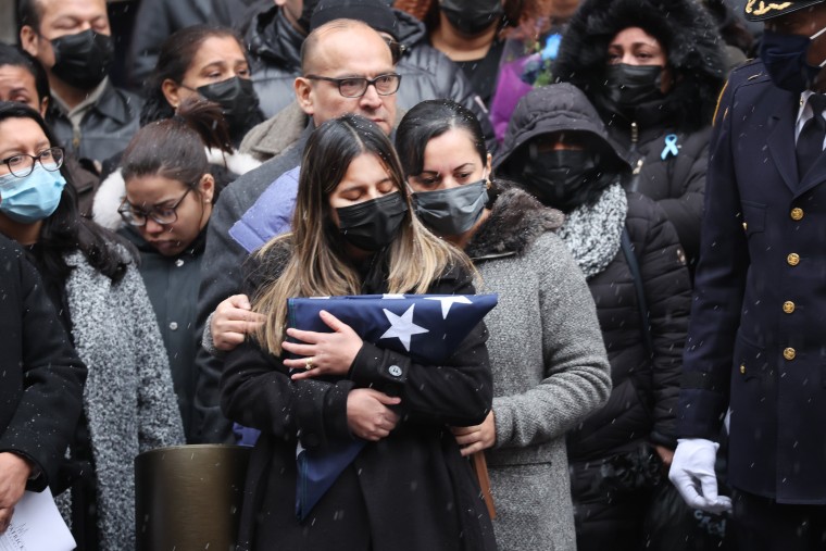Dominique Rivera, the wife of fallen NYPD Officer Jason Rivera, holds a flag from his casket during his funeral at St. Patrick's Cathedral on January 28, 2022 in New York City. The 22-year-old NYPD officer was shot and killed on January 21 in Harlem while