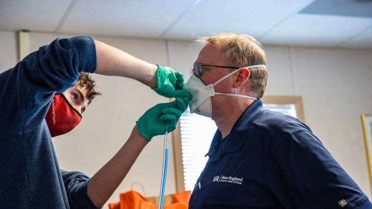 Un trabajador médico prueba una mascarilla N95 a un trabajador en un centro de salud en Massachusetts.