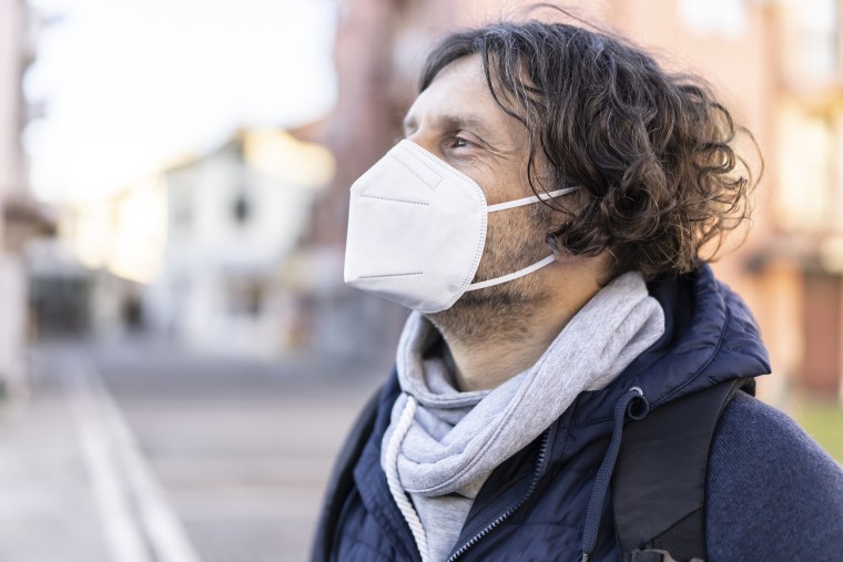 Portrait of a man wearing a protective face mask in accordance with the European health guidelines.