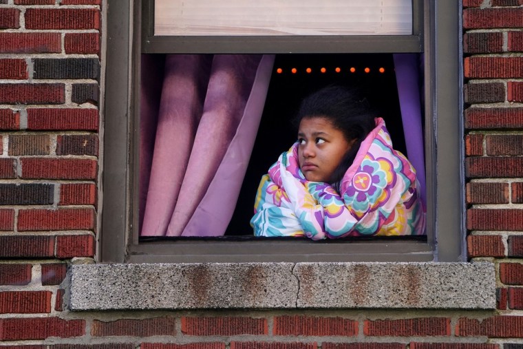 Una mujer mira por la ventana durante una conferencia de prensa en un edificio que se incendió en el Bronx, Nueva York, el 10 de enero de 2022.