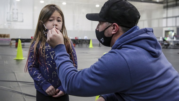 Bret Wolf, de 33 años, recoge una muestra nasal de su hija de 5 años, Elle Wolf, en San Bernardino,  California.