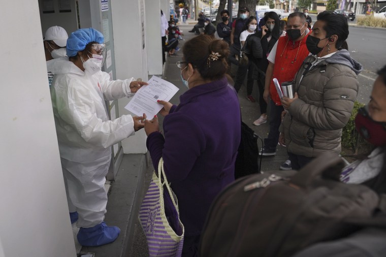 Una mujer recibe el resultado de una prueba de COVID-19 afuera de una farmacia en la Ciudad de México, el lunes 10 de enero. En diciembre, los casos del virus se triplicaron en México.