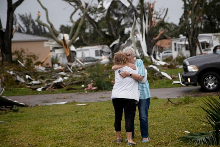 Los residentes se abrazan después de que un tornado azotara el área de Iona en Florida el domingo.
