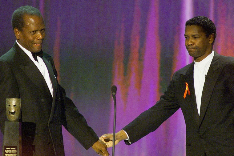 Image: Sidney Poitier is congratulated by actor Denzel Washington as he accepts the Life Achievement Award at the Screen Actors Guild Awards in Los Angeles, 12 March 2000.
