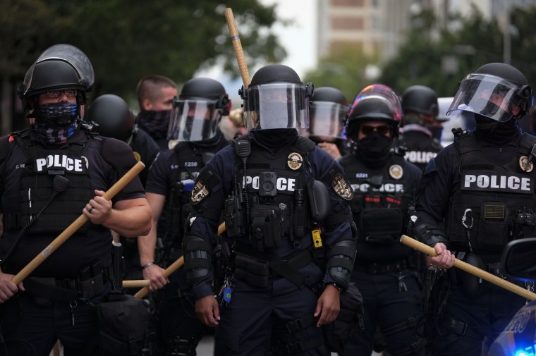 Police officers line up in downtown Louisville, Ky., as protestors march on Sept. 23, 2020.