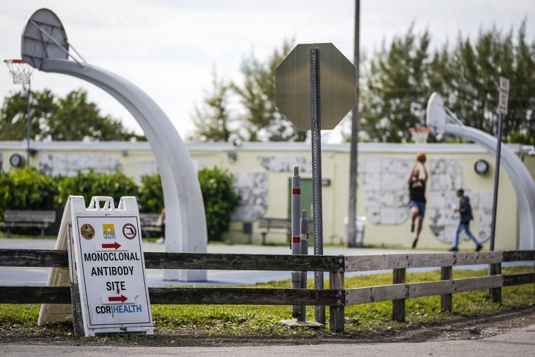 Image: Men play basketball at Tropical Park, outside a site that had been administering monoclonal antibody treatments for Covid-19 until closing in compliance with federal regulations Jan. 25, 2022, in Miami.