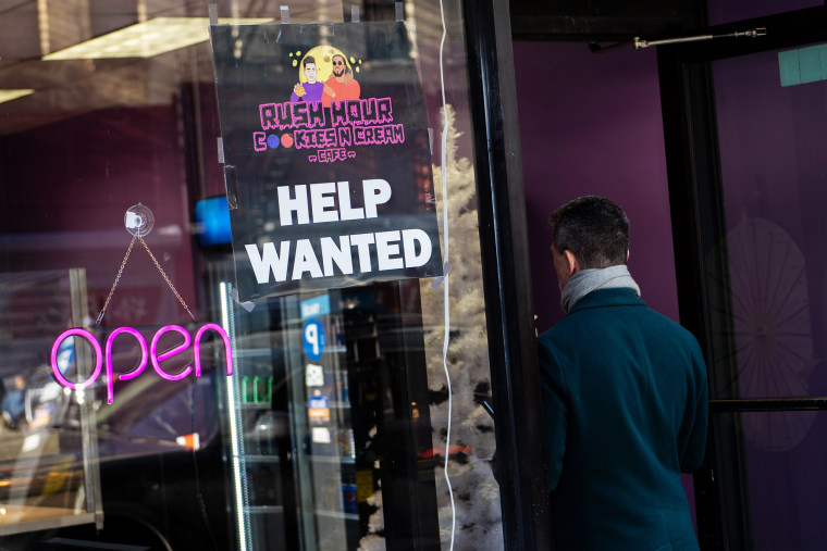 Image:  A person walks into a shop with "Help Wanted" sign on Jan. 12, 2022 in New York City.