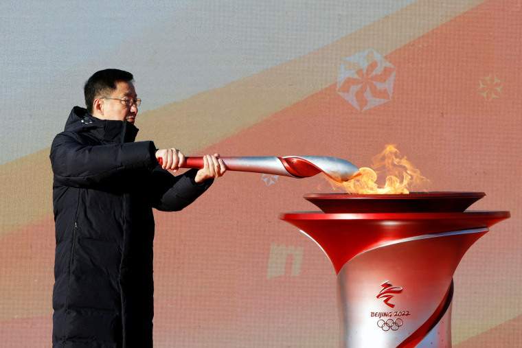 Chinese Vice Premier Han Zheng lights an Olympic torch from the cauldron during the launching ceremony at the Olympic Forest Park in Beijing on Feb. 2, 2022.