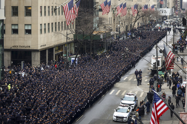 Image: New York Police officers line up along Fifth Avenue outside St. Patrick's Cathedral for Officer Wilbert Mora's funeral on Feb. 2, 2022, in New York.
