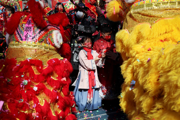 Image: A girl in traditional costume stands amid lion dancers during a Chinese Lunar New Year celebrations in Chinatown in New York City on Feb. 1, 2022.