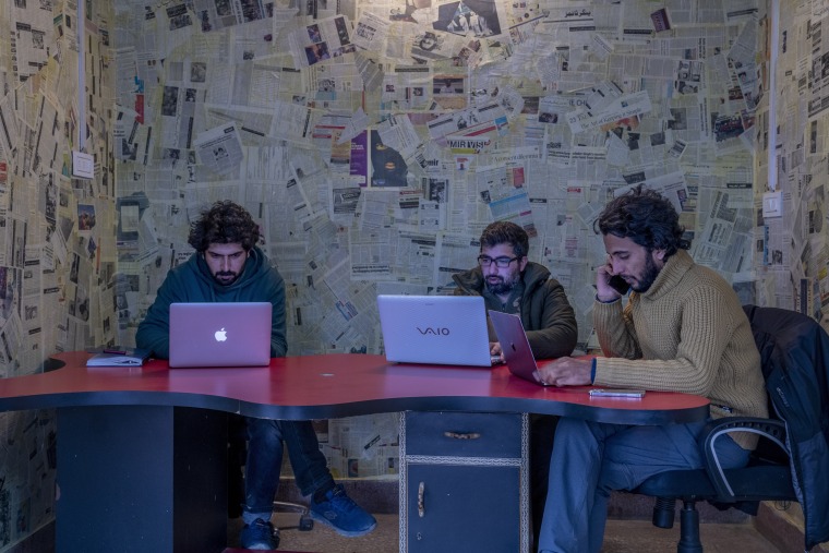 Fahad Shah, right, editor-in-chief of Kashmir Walla, works inside the newsroom at his office in Srinagar, Indian controlled Kashmir, on Jan. 21, 2022.