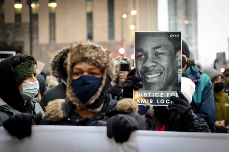 Image: A demonstrator holds a photo of Amir Locke during a rally in protest of the killing of Amir Locke, outside the Hennepin County Government Center in Minneapolis on Feb. 5, 2022.