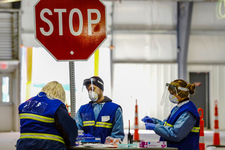 Healthcare workers process nasal swab samples at a drive-thru Covid-19 testing site inside the Alliant Energy Center complex in Madison, Wisc., on Oct. 31, 2020.