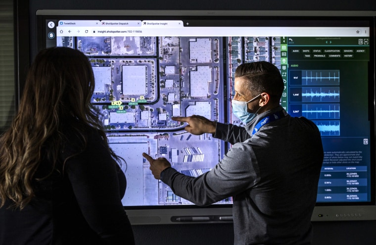 Image: Las Vegas Police Department Detective Kyle Downie, right, shows specialist Amber Stringer the ShotSpotter dispatch program at police headquarters on Jan. 13, 2021.