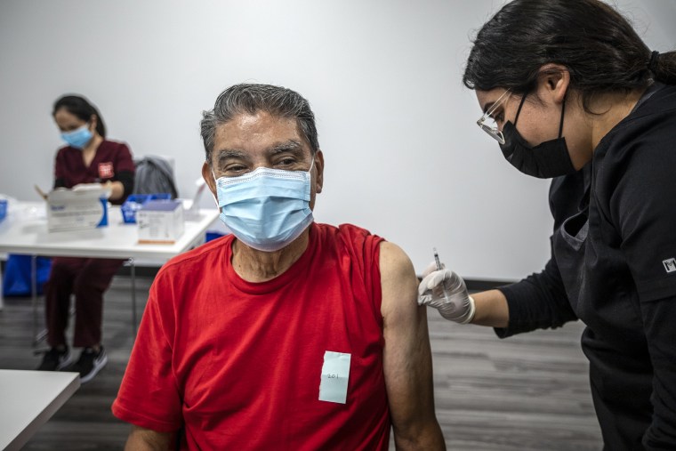 Irene Michel, right, gives Jaime Sores, 70, left, a Covid-19 vaccination booster at a Covid-19 vaccine clinic on Nov. 17, 2021 in El Monte, Calif.