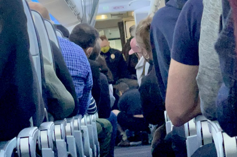 The unruly passenger was subdued by crew members and passengers, American Airlines said.