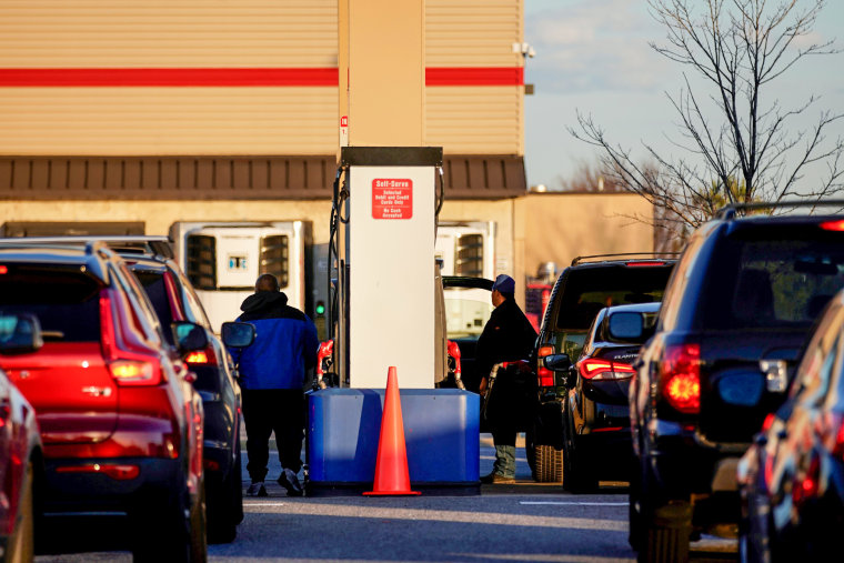 People fuel up cars at a gas station in Washington, D.C., on Feb. 10, 2022.