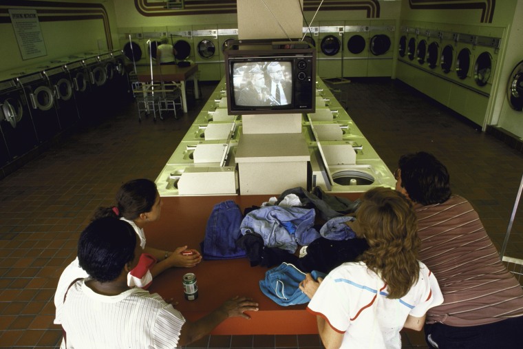 Patrons at a laundromat watch the televised broadcast of Lt. Col. Oliver L. North's testimony before the joint Congressional hearing into Iran-Contra affair on July 1, 1987.