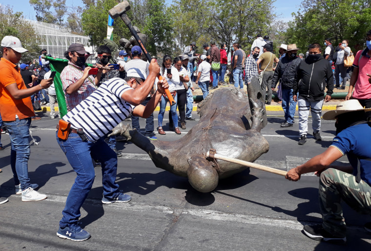 Image: Members of the Indigenous Council destroy the statue of Fray Antonio de San Miguel during a protest in Morelia