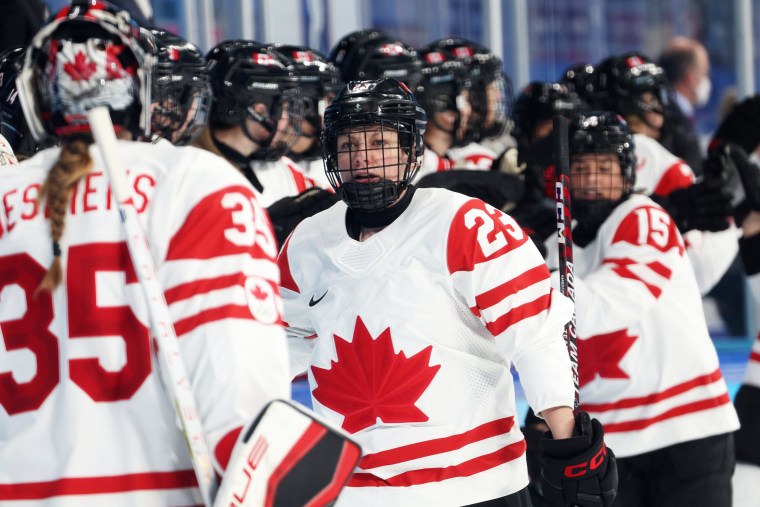 Canada's Erin Ambrose, center, celebrates with teammates on the bench after scoring a goal in the first period during the ice hockey playoff semifinal match between against Switzerland at the Beijing 2022 Winter Olympic Games on Feb. 14, 2022.