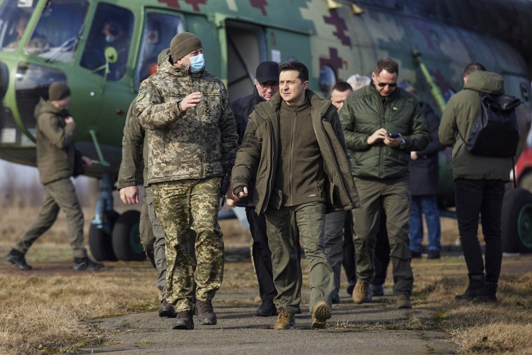 Image: Ukrainian President Volodymyr Zelenskyy, center, arrives to attend a military drill outside the city of Rivne, northern Ukraine, on Feb. 16, 2022.