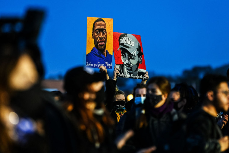 Demonstrators hold portraits George Floyd and Daunte Wright during the sixth night of protests over the police shooting death of Daunte Wright in Brooklyn Center, Minn., on April 16, 2021.
