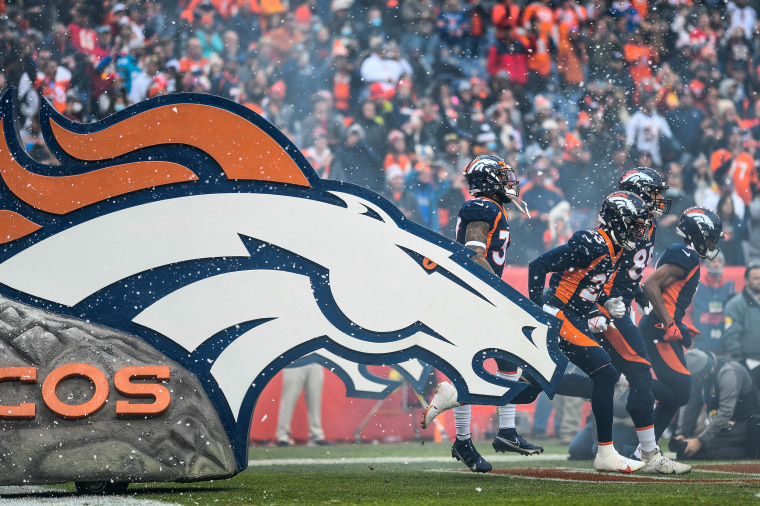 Denver Broncos players run onto the field before a game against the Kansas City Chiefs on Jan. 8, 2022, in Denver.