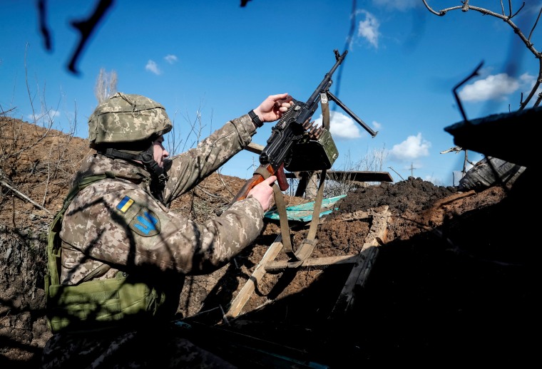 Image: Ukrainian service member holds a machine gun in a trench on the front line near the village of Travneve